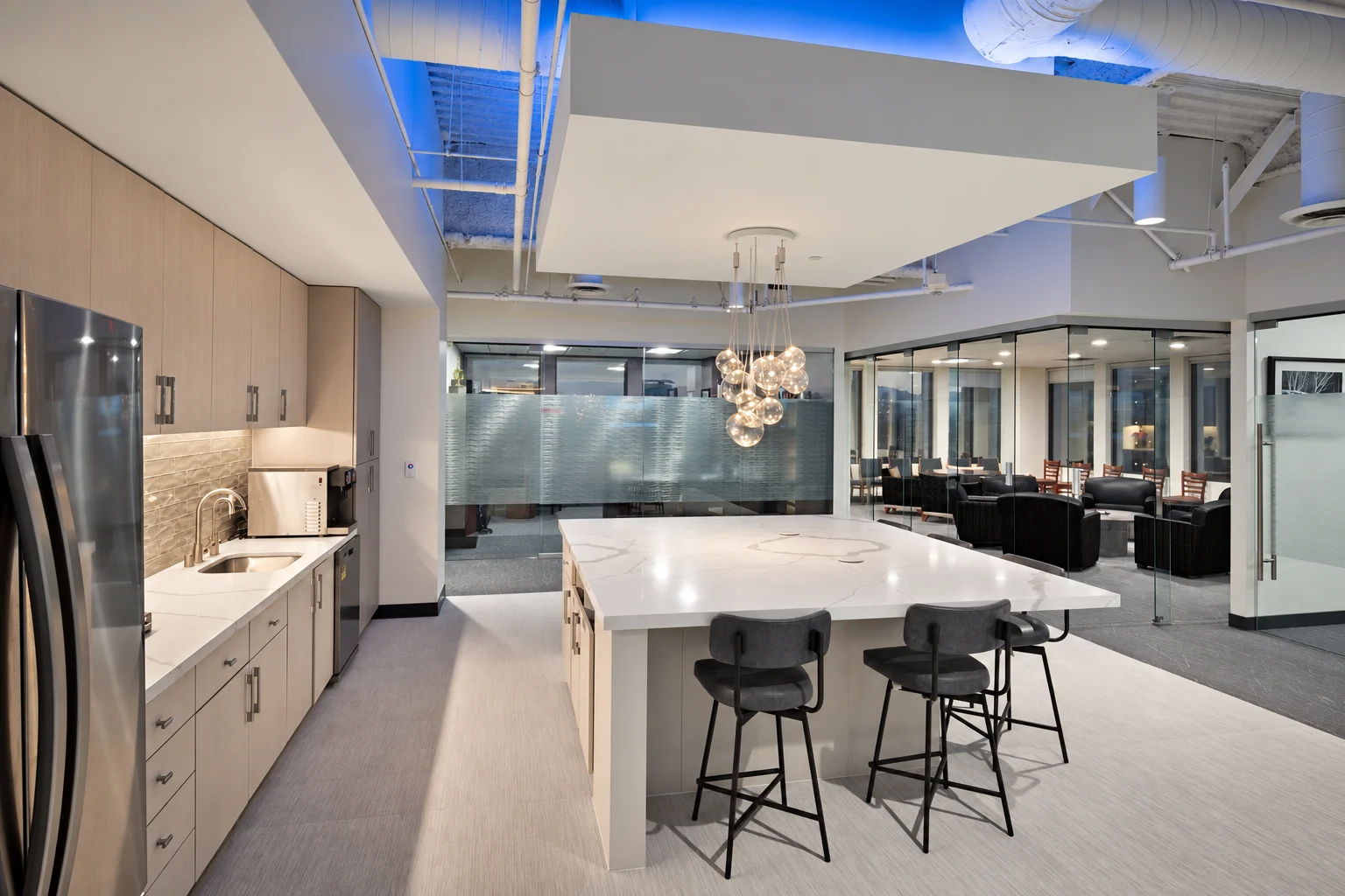 Holley Driggs Law Offices breakroom with stone island, pendant lighting, and glass-walled meeting spaces